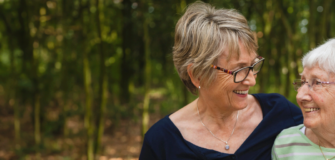 Pensionistin und Angehörige lächeln sich an