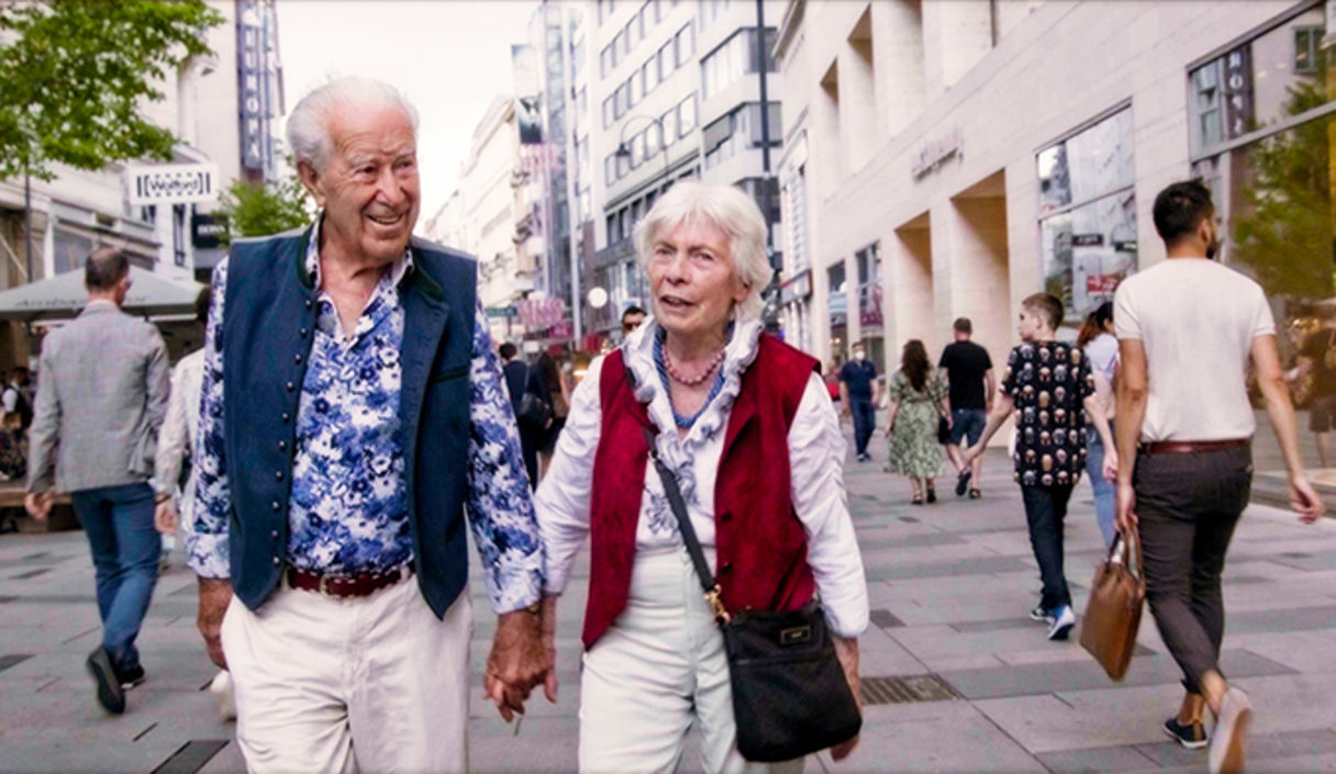 Älteres Ehepaar läuft durch Fußgängergasse Hand in Hand