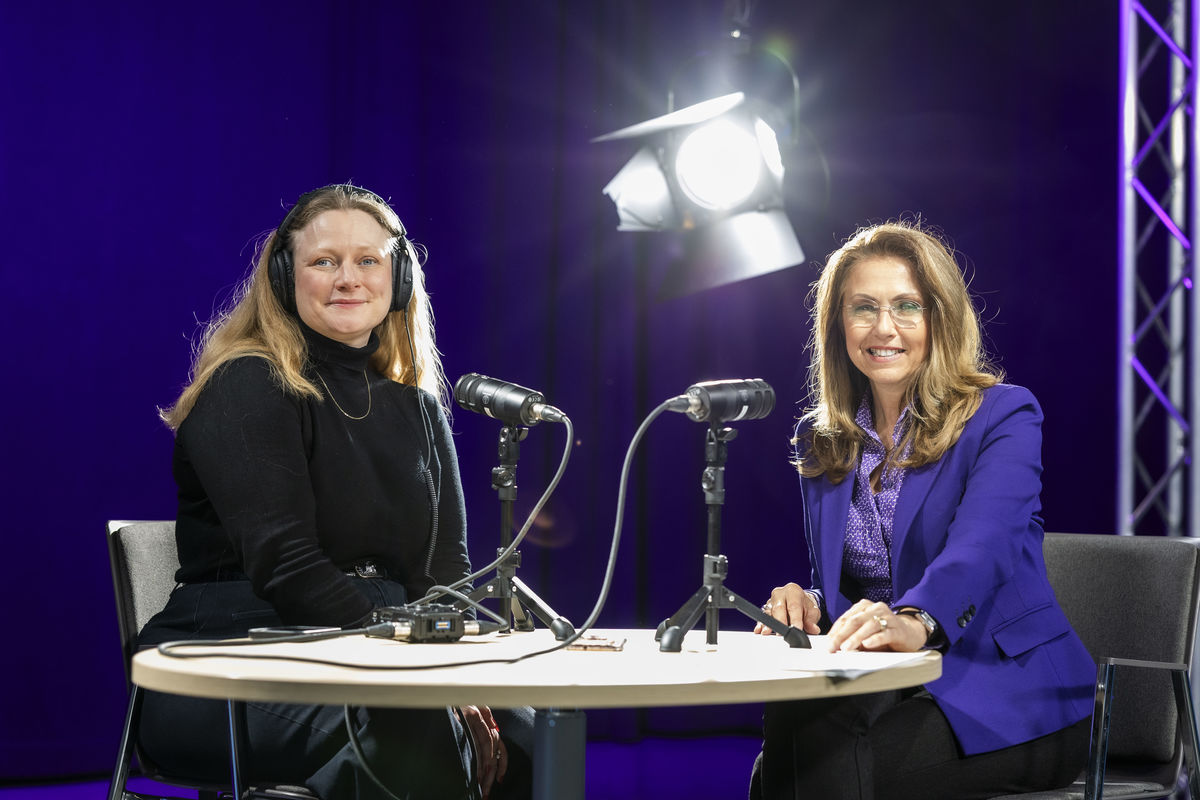 Asta Krjci-Sebesta und Marion Seidenberger nehmen einen Podcast auf und lächeln in die Kamera