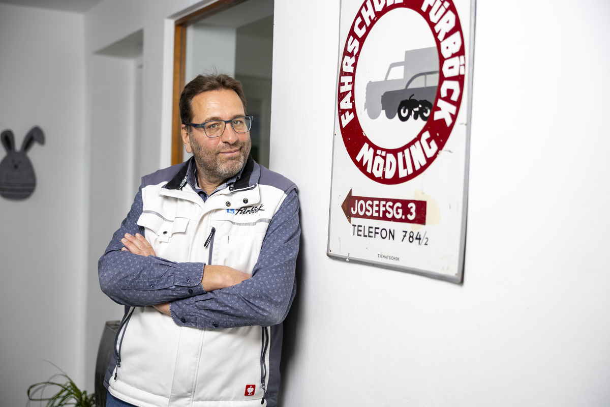 Alexander Seger lehnt an eine Wand und lächelt in die Kamera