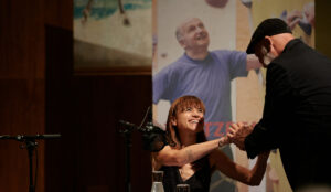 Erich Fenninger und Mari Lang schütteln sich die Hände und lächeln sich an