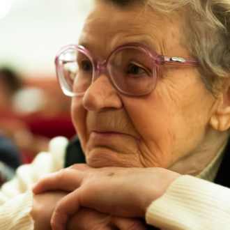 Pensionistin lehnt sich an ihrem Kinn an und sieht nachdenklich aus