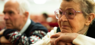 Pensionist und Pensionistin lehnen sich an ihrem Kinn an und sehen nachdenklich aus