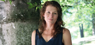 Portrait von Johanna Constantini in einem Park. Sie blickt in die Kamera.